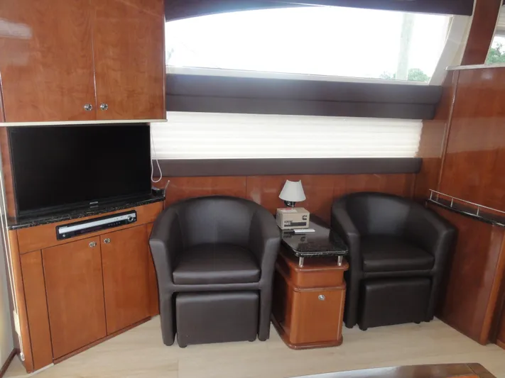  Yacht Photos Pics Interior of 2009 Meridian 441 Sedan with leather chairs, TV, and wooden cabinetry.