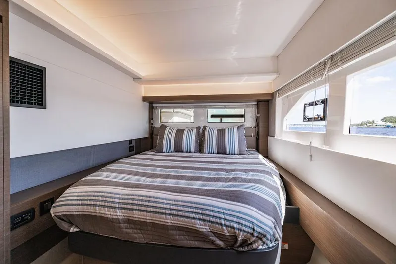 Nautilus Yacht Photos Pics Luxurious bedroom interior of 2021 Leopard 53 Powercat with striped bedding and large windows.