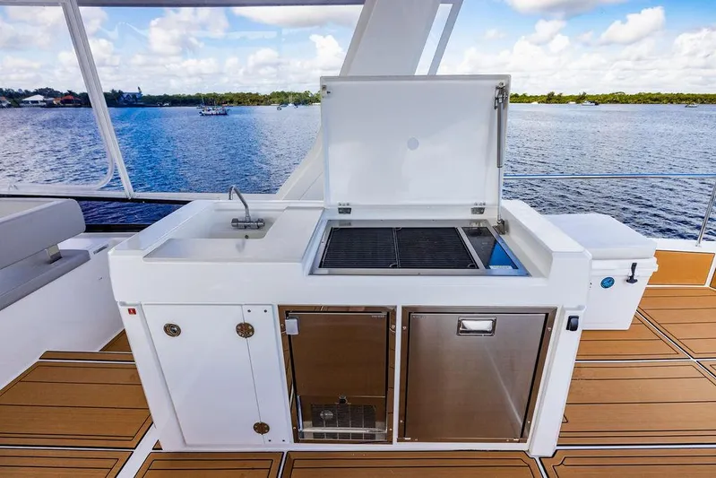 Nautilus Yacht Photos Pics Outdoor kitchen on 2021 Leopard 53 Powercat yacht with grill and sink, overlooking water.