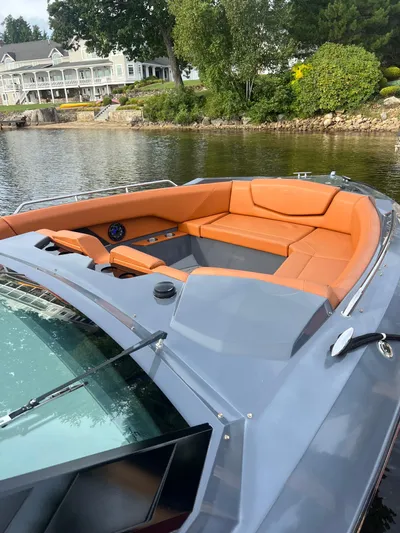  Yacht Photos Pics 2016 Cruisers Yachts 338 SOUTH BEACH with orange seating, docked by a scenic waterfront.