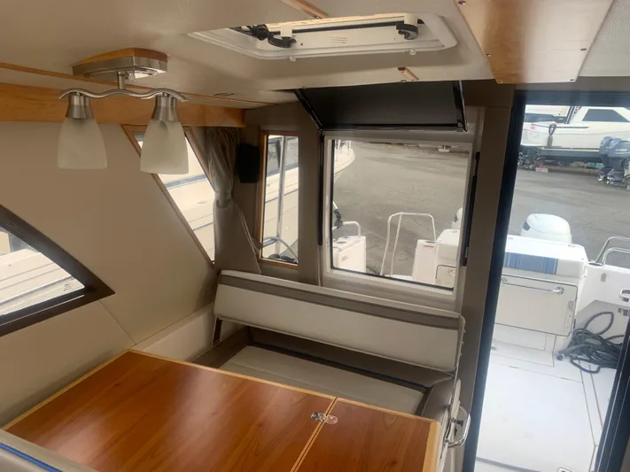  Yacht Photos Pics Interior of 2018 Cutwater C 302 Coupe boat with wooden table and seating.