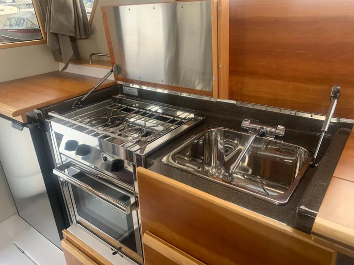  Yacht Photos Pics 2018 Cutwater C 302 Coupe kitchen with stainless steel stove and sink.