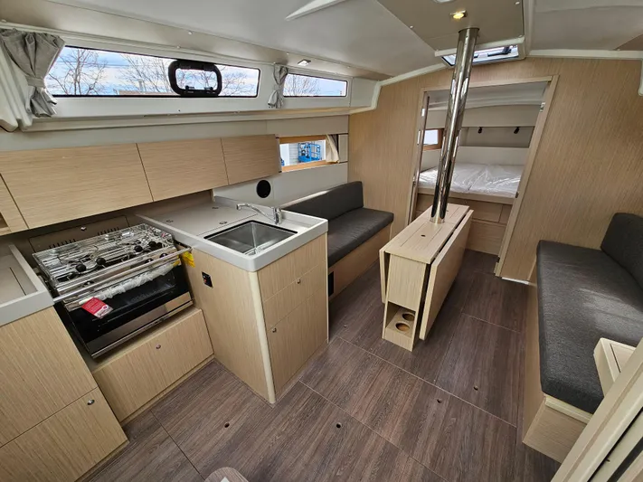  Yacht Photos Pics 2024 Beneteau Oceanis 38.1 interior with modern kitchen, seating, and cozy sleeping area.