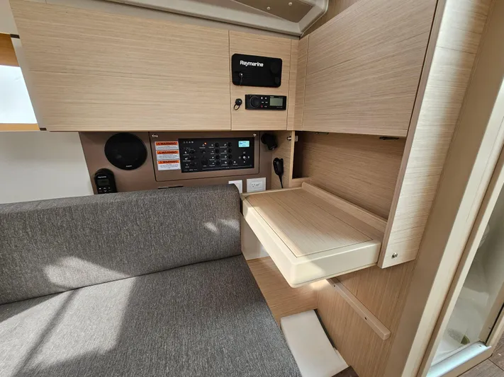  Yacht Photos Pics 2024 Beneteau Oceanis 38.1 interior with modern navigation panel and cozy seating area.