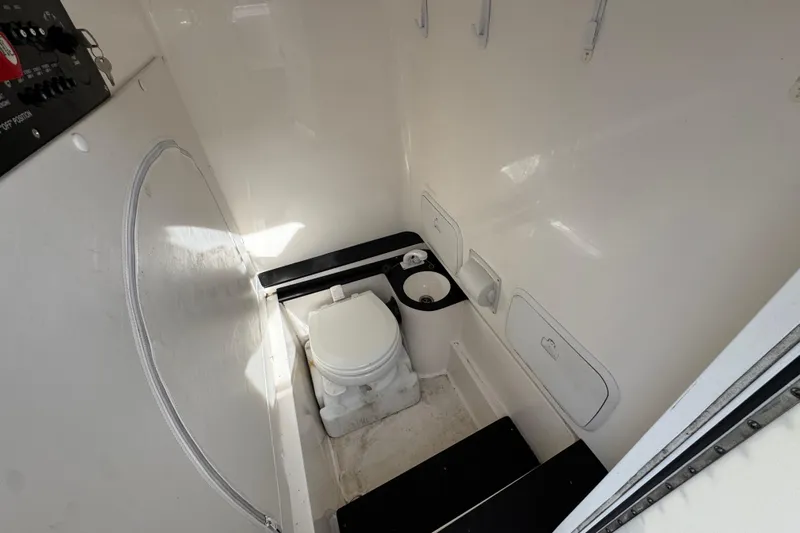  Yacht Photos Pics 2023 Fountain 38 Tournament Edition boat interior with compact marine toilet and storage compartments.