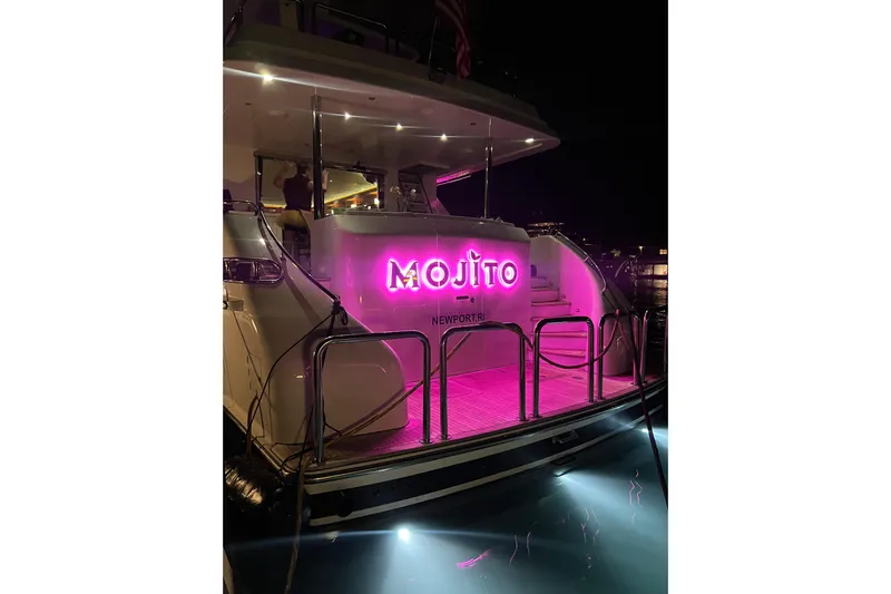 Mojito Yacht Photos Pics Luxury 2006 Hargrave Raised Pilothouse yacht with vibrant pink "Mojito" sign at night.