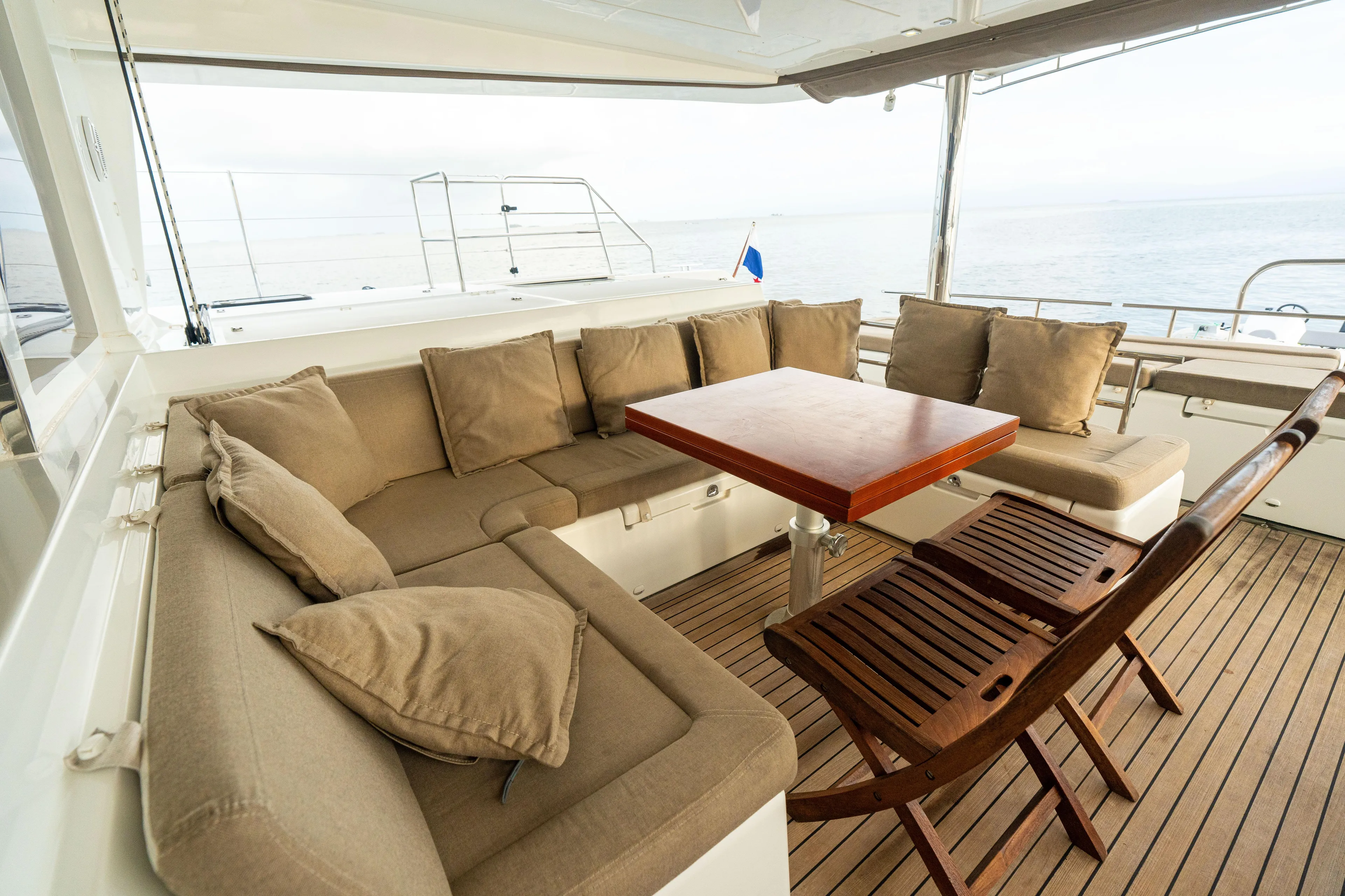 LibertÉ Yacht Photos Pics Luxurious Lagoon 560 yacht deck with cushioned seating and wooden table, 2011 model.