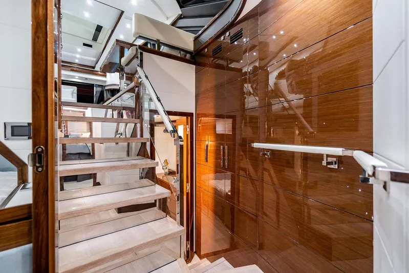  Yacht Photos Pics Luxurious interior of 2026 Neptunus 650E yacht with modern staircase and glossy wood paneling.