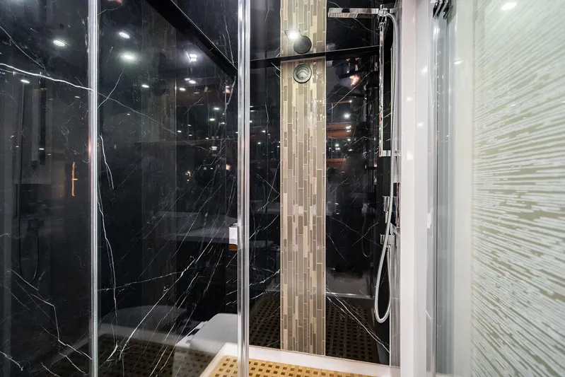  Yacht Photos Pics Luxurious Neptunus 650E 2026 yacht shower with sleek black marble and modern fixtures.