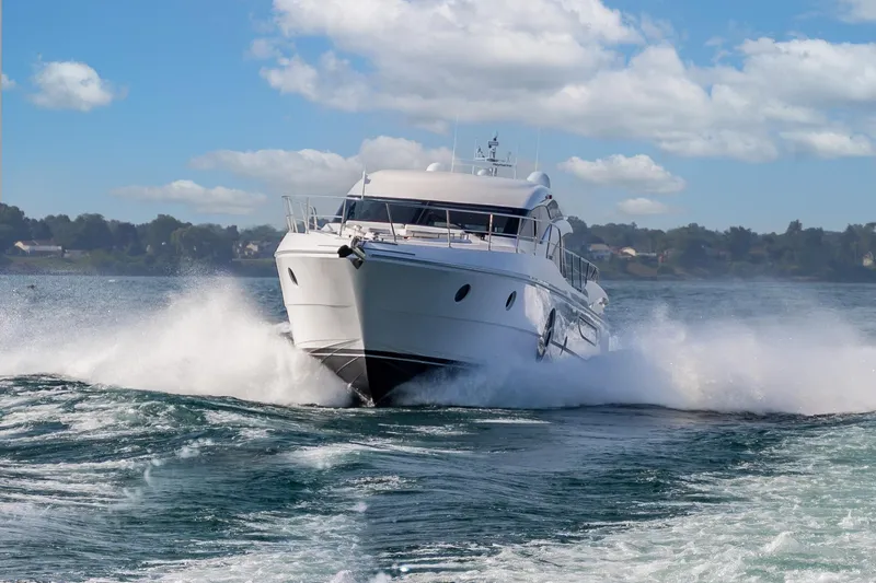  Yacht Photos Pics 2026 Neptunus 650E yacht cruising on open water under a clear blue sky.