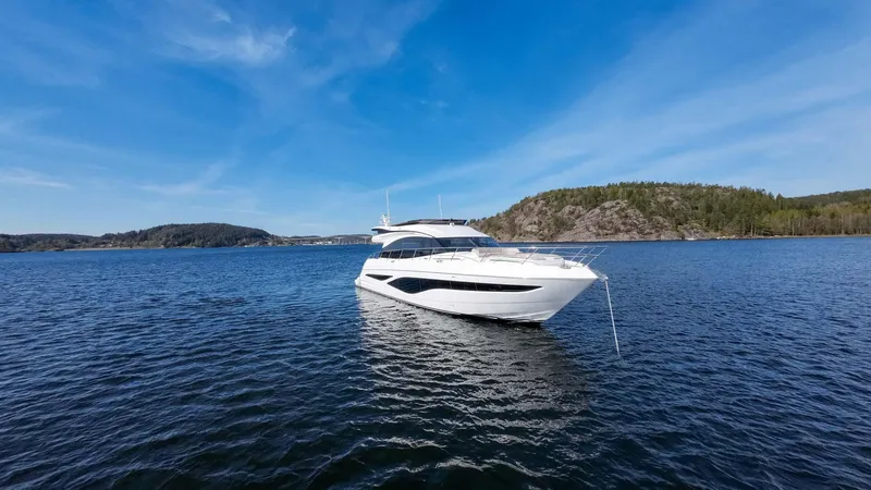 F65012 Yacht Photos Pics 2024 Princess F65 yacht on serene blue water with scenic background.