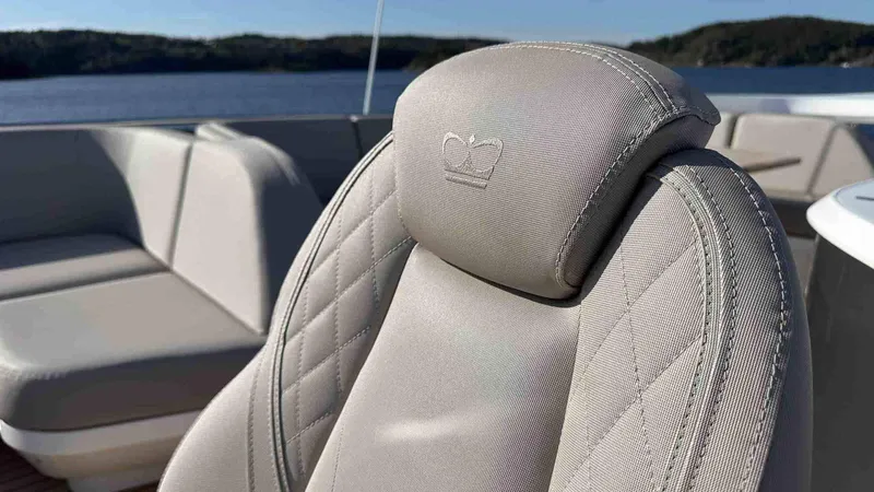 F65012 Yacht Photos Pics Luxurious seating on 2024 Princess F65 yacht with elegant stitching and crown emblem.
