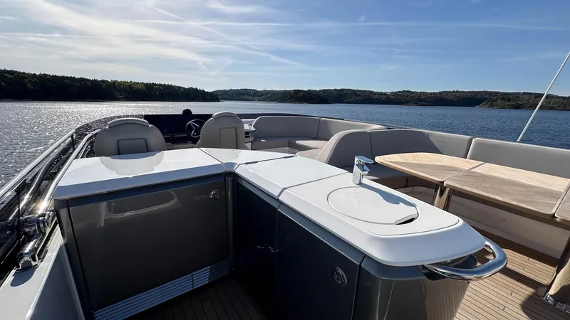 F65012 Yacht Photos Pics 2024 Princess F65 yacht deck with seating, kitchenette, and scenic water view.