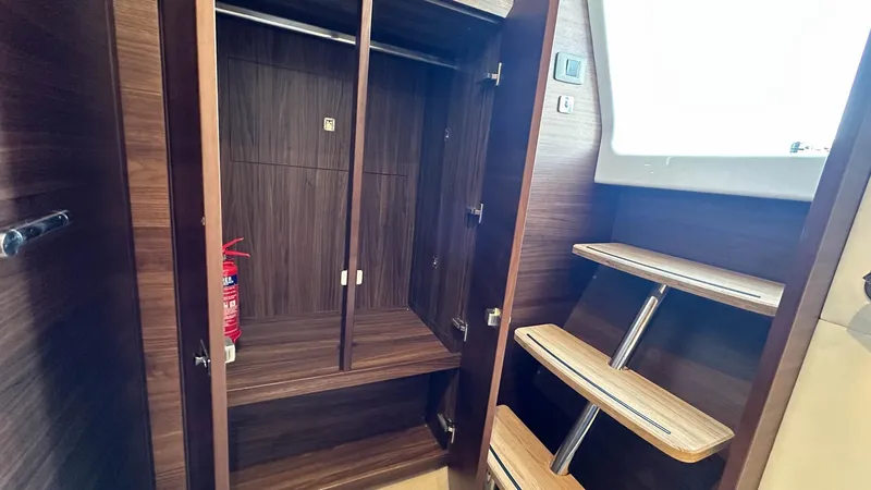 F65012 Yacht Photos Pics 2024 Princess F65 yacht interior with wooden closet and stairs, featuring a fire extinguisher.