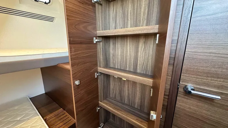 F65012 Yacht Photos Pics 2024 Princess F65 yacht interior with open wooden cabinet and bunk bed.