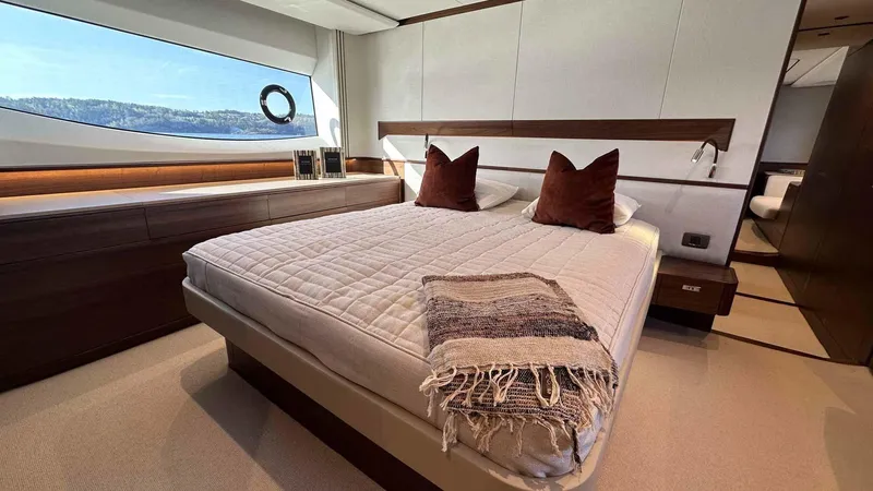 F65012 Yacht Photos Pics Luxurious bedroom interior of 2024 Princess F65 yacht with elegant bedding and scenic window view.