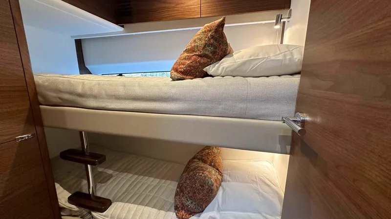 F65012 Yacht Photos Pics Bunk beds in 2024 Princess F65 yacht cabin with wooden interior and decorative pillows.