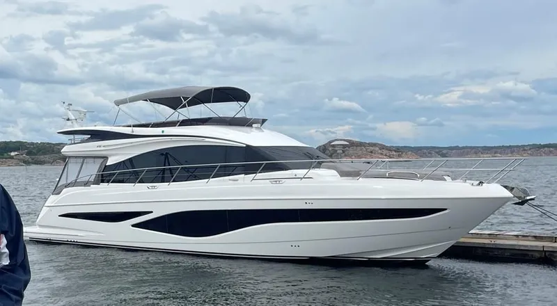 F65012 Yacht Photos Pics 2024 Princess F65 yacht docked on a calm sea under a cloudy sky.