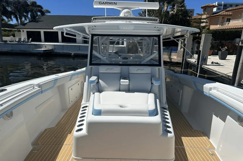 Yacht Photos Pics 2018 Yellowfin 42 boat with spacious deck and seating, docked by waterfront homes.