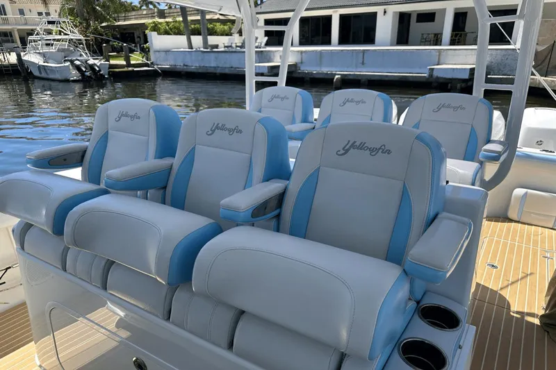 Yacht Photos Pics 2018 Yellowfin 42 boat with blue and white seating, docked by the water.