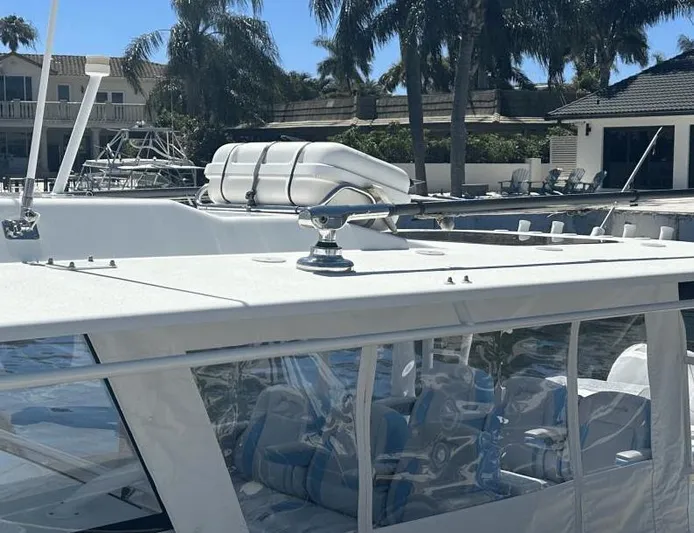 Yacht Photos Pics 2018 Yellowfin 42 boat docked near palm trees and waterfront homes.