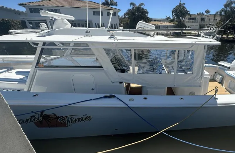 Yacht Photos Pics 2018 Yellowfin 42 boat docked by waterfront homes, clear day.