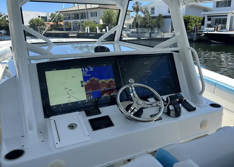  Yacht Photos Pics 2018 Yellowfin 42 boat dashboard with navigation screens and steering wheel.