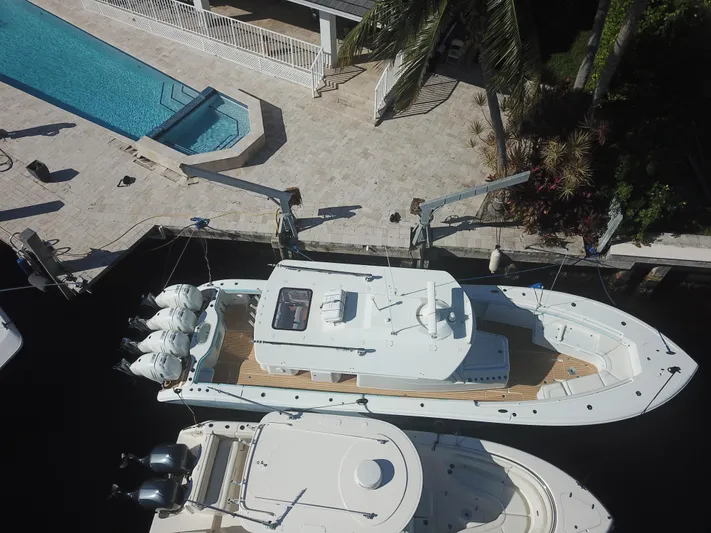  Yacht Photos Pics Aerial view of a 2018 Yellowfin 42 boat docked near a poolside area.