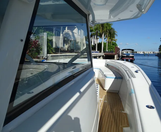  Yacht Photos Pics 2018 Yellowfin 42 boat docked by a waterfront, showcasing sleek design and spacious deck.