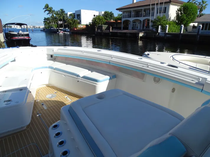  Yacht Photos Pics 2018 Yellowfin 42 boat interior with seating, docked by waterfront homes.