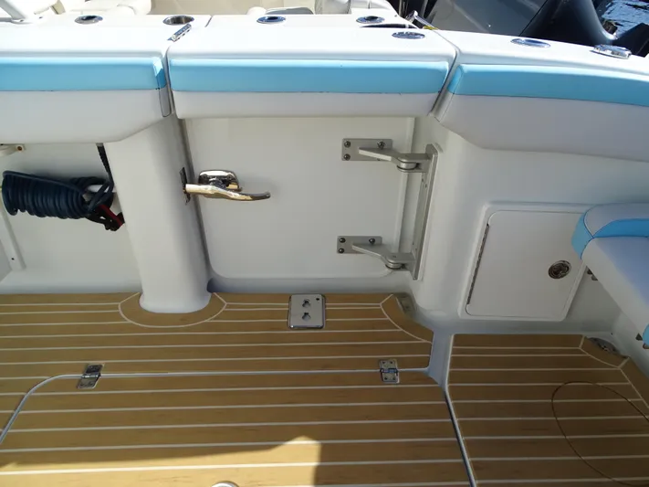  Yacht Photos Pics 2018 Yellowfin 42 boat deck with teak flooring and blue cushioned seating.