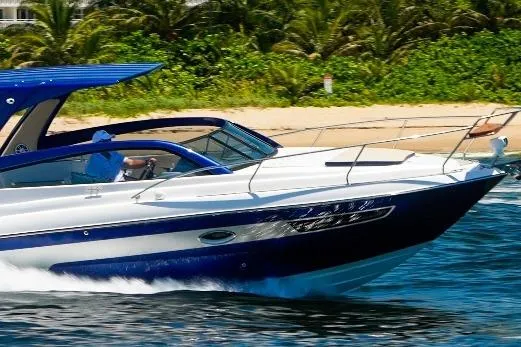  Yacht Photos Pics 2024 Hanover 305 White & Blue Edition boat cruising near a tropical beach.