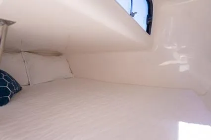  Yacht Photos Pics 2024 Hanover 305 White & Blue Edition cabin interior with white bedding and blue pillow.