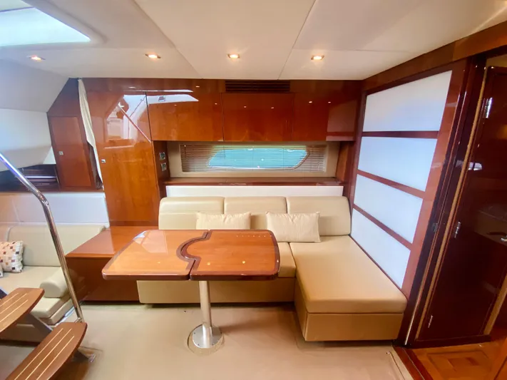 Hyde-a-way Yacht Photos Pics Interior of 2010 Sea Ray 450 Sundancer yacht with beige seating and wooden table.