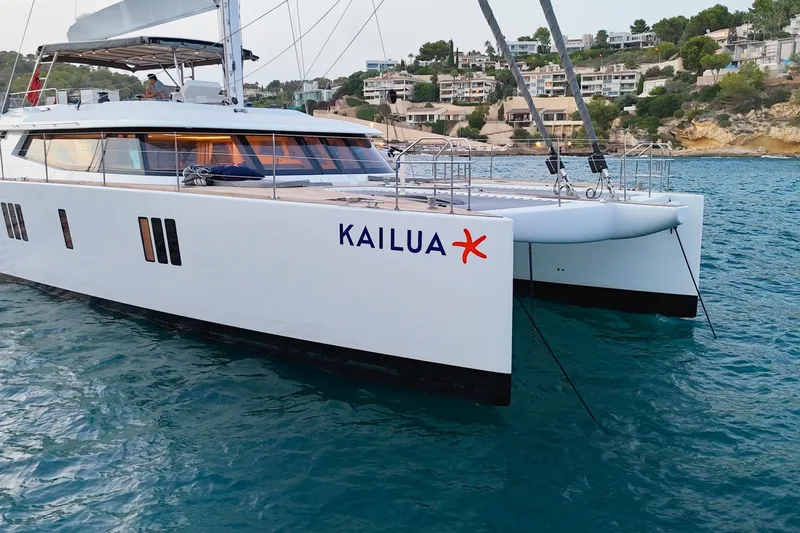 Kailua Yacht Photos Pics Luxury Sunreef 74 catamaran, 2018 model, named Kailua, anchored near coastal homes.