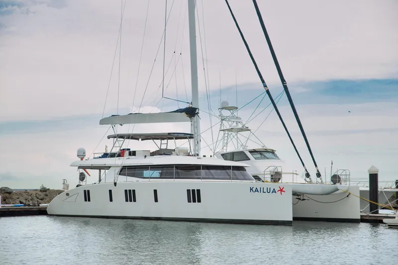 Kailua Yacht Photos Pics Luxury Sunreef 74 catamaran, 2018 model, docked in a serene marina setting.