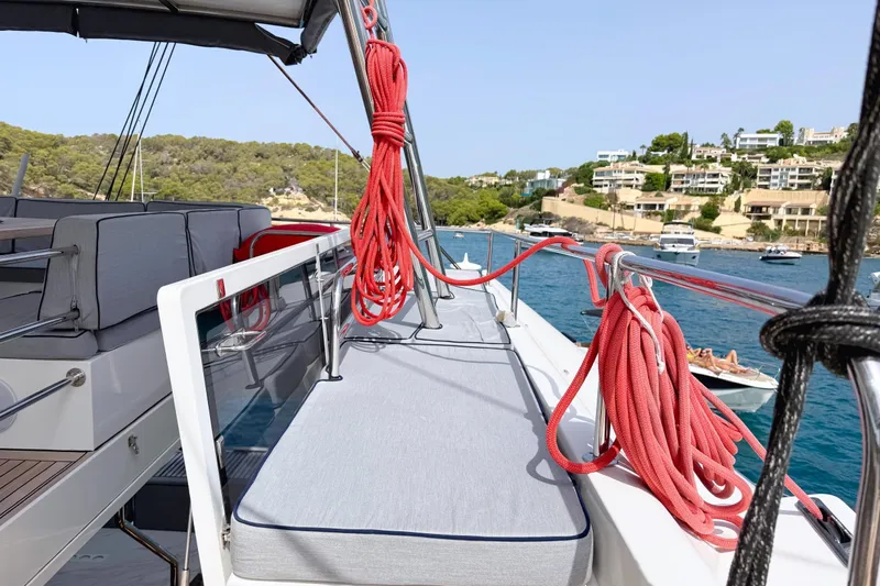 Kailua Yacht Photos Pics Luxurious 2018 Sunreef 74 yacht deck with seating, moored in scenic coastal area.