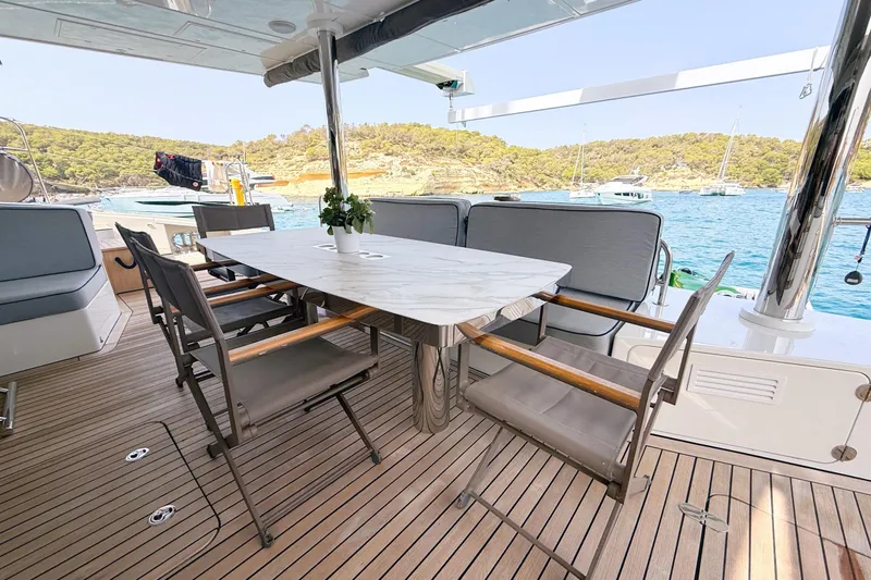 Kailua Yacht Photos Pics Luxurious Sunreef 74 yacht deck with elegant dining area, overlooking serene blue waters, 2018 model.