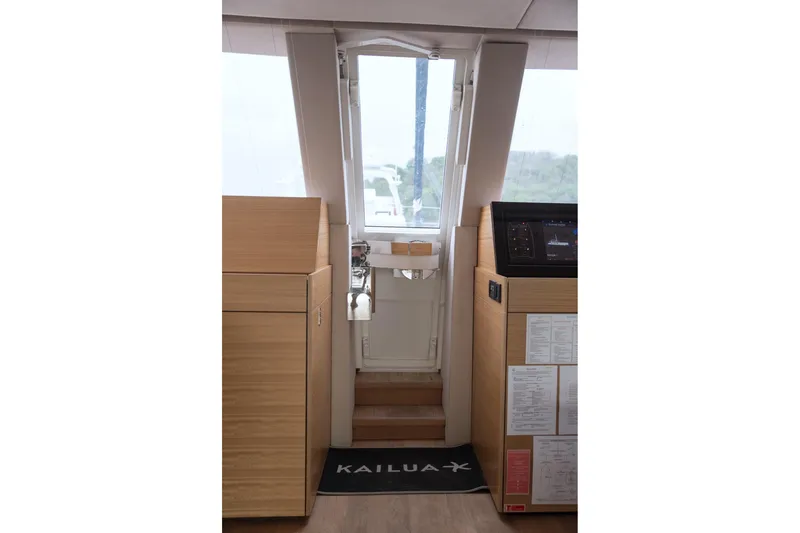 Kailua Yacht Photos Pics Interior view of 2018 Sunreef 74 yacht, featuring modern wooden cabinetry and navigation equipment.