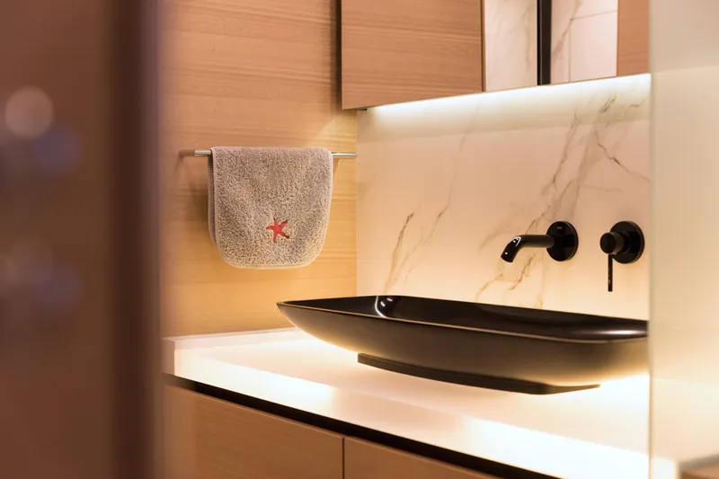 Kailua Yacht Photos Pics Luxurious bathroom on 2018 Sunreef 74 yacht with modern black sink and elegant lighting.