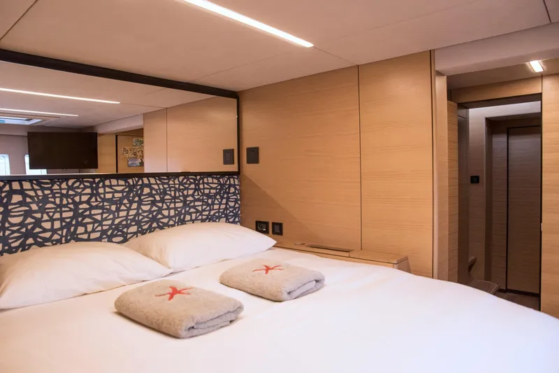 Kailua Yacht Photos Pics Luxurious Sunreef 74 yacht bedroom interior, 2018 model, featuring modern design and cozy bedding.