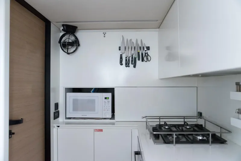 Kailua Yacht Photos Pics Modern kitchen in 2018 Sunreef 74 yacht with microwave, gas stove, and knife set.