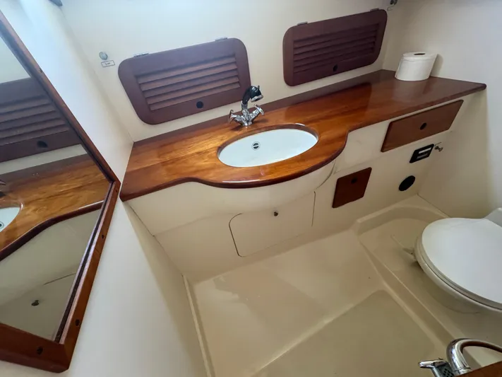Tamarack Yacht Photos Pics Hinckley Picnic 1999 boat bathroom with wooden countertop, sink, and toilet.