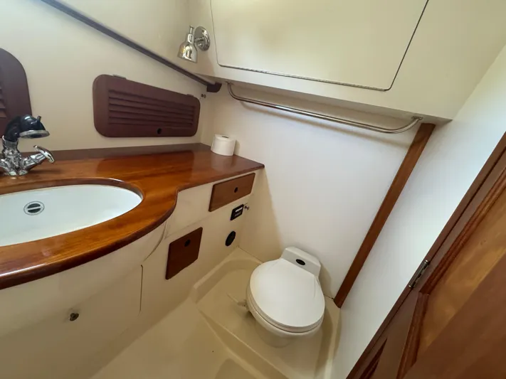 Tamarack Yacht Photos Pics 1999 Hinckley Picnic boat bathroom with wooden countertop and compact toilet.