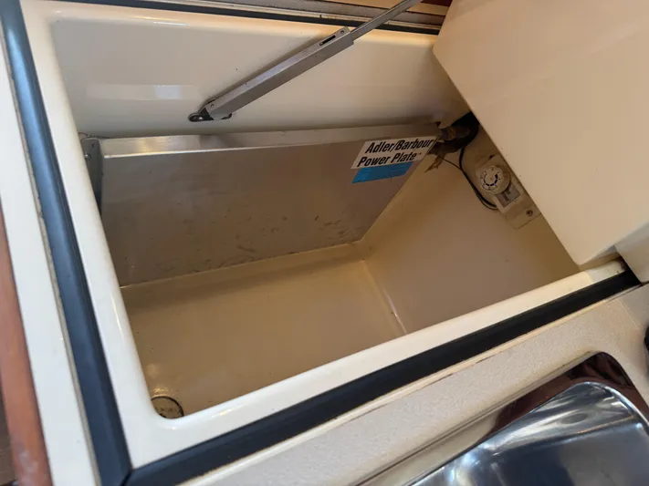 Tamarack Yacht Photos Pics Open storage compartment in 1999 Hinckley Picnic boat with Adler Barbour Power Plate.