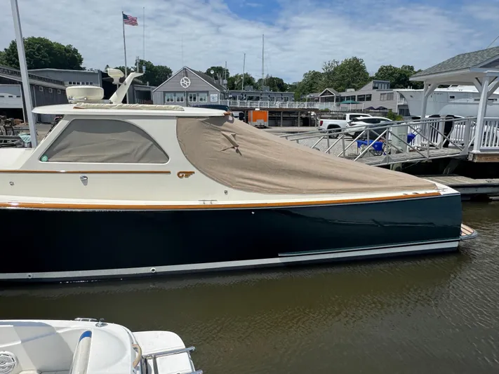 Tamarack Yacht Photos Pics 1999 Hinckley Picnic boat docked with cover, marina background, American flag visible.