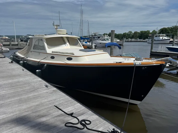 Tamarack Yacht Photos Pics 1999 Hinckley Picnic boat docked at a marina under a cloudy sky.