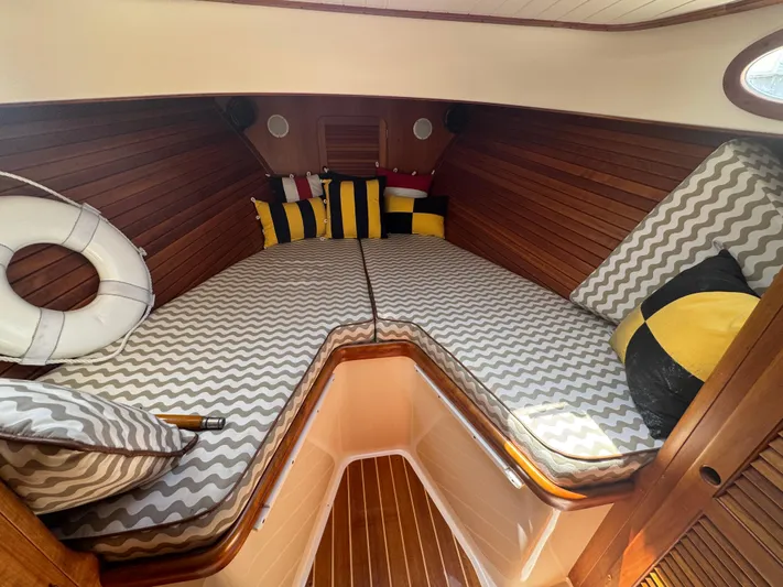 Tamarack Yacht Photos Pics Cozy cabin interior of 1999 Hinckley Picnic boat with striped cushions and colorful pillows.