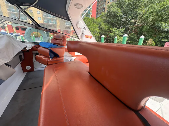  Yacht Photos Pics 1999 Sea Ray Sundancer 50 interior with brown leather seating and cityscape background.