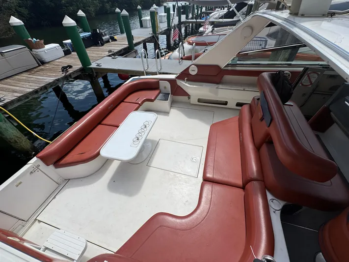  Yacht Photos Pics 1999 Sea Ray Sundancer 50 yacht with red seating and white table at a marina dock.